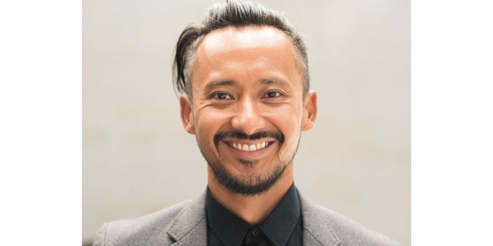 Professional man in grey suit smiles in portrait shot
