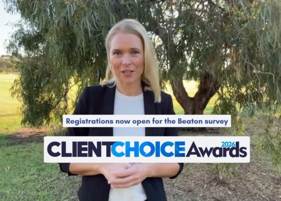 Blonde woman in business attire speaks to camera